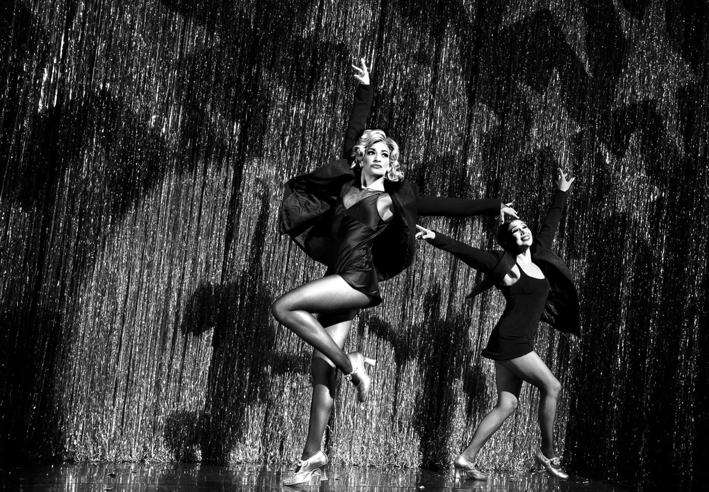 Chicago performers dancing on stage in black costumes